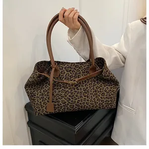 Close-up of leopard print tote bag featuring leather straps and premium metal hardware