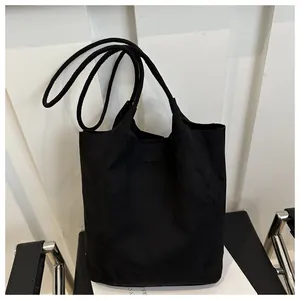 Detail view of black matte minimalist tote bag featuring thin round shoulder straps