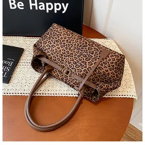 Macro shot of stylish leopard print tote bag with brown leather handles on lace cloth