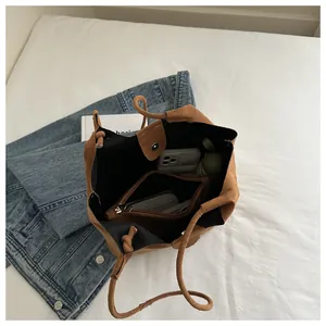 Top view of brown faux suede tote bag interior with a zippered inner pouch