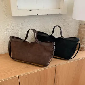 Detail of vintage brown and black tote bags with matte texture and dual strap design