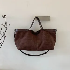 Detail of a large vintage brown tote bag with matte finish and dual handle straps