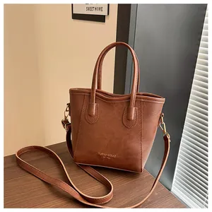 Macro shot of brown faux leather texture and gold embossed Fashion & Bag lettering on tote