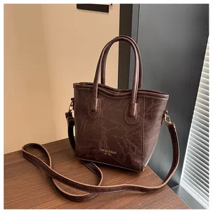 Detailed side view of dark brown vintage oil-wax texture crossbody bag with top handles