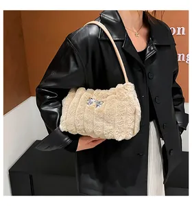 Détail du sac à bandoulière en fausse fourrure beige avec texture et nœud argenté