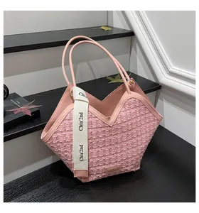 Detail of pink tweed bucket bag with V-shaped edge and decorative logo ribbon