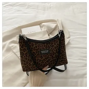 Close-up of leopard print handbag with plush texture, black leather trim and silver hardware