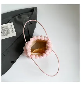 Détail du sac à main en peluche rose montrant la doublure jaune et la poche interne