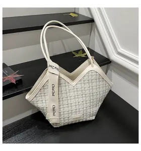 Detailed close-up of textured checkered fabric and canvas handles on a bucket bag