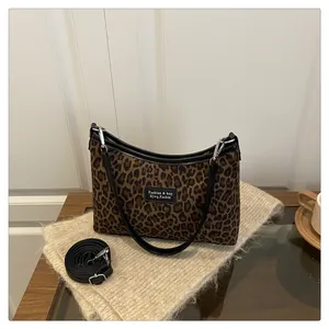 Detail of leopard print canvas bag showing the adjustable strap and faux leather trim