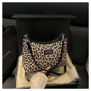 Close-up of leopard print handbag with leather trim in a black premium gift box