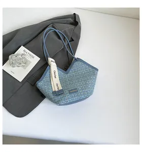 Blue tweed bucket bag with V-shaped opening and woven texture on a white background