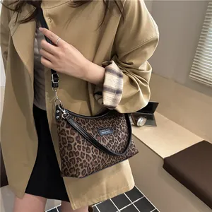 Leopard print crossbody bag with black leather trim and adjustable shoulder strap