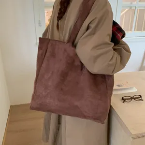 Detail of large corduroy tote bag in vintage rose pink shown on model shoulder