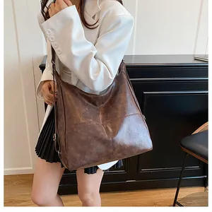Detail of dark brown faux leather tote bag with decorative cross-stitching on the surface