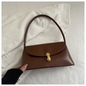 Macro detail of dark brown leather handbag featuring a premium gold metallic buckle clasp