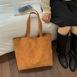 Detailed close-up of brown suede tote bag featuring soft texture and spacious design