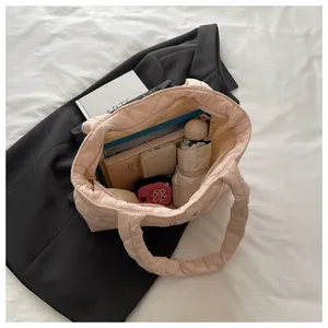 Top-down view showing interior capacity of pink quilted tote bag with tablet and essentials