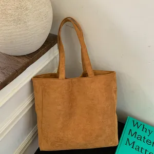 Detail of vertical brown corduroy tote bag showing striped velvet texture and top handles