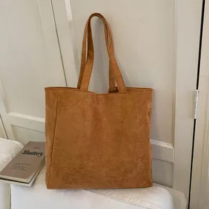 Close-up of caramel brown tote bag showing its soft suede texture and wide straps