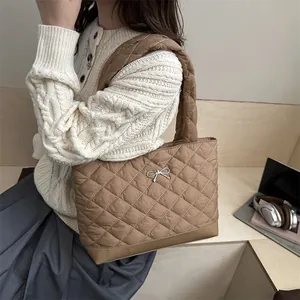 Quilted tote bag with silver bow accent and rhombic stitching for women's daily commute