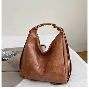 Detail of caramel brown hobo bag with lychee texture faux leather and silver zipper