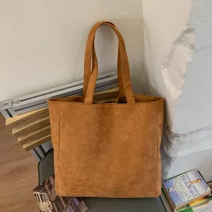 Caramel brown suede tote bag with large capacity shown in a stylish indoor setting