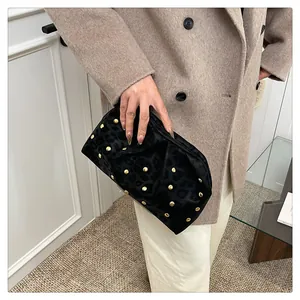 Close-up of black velvet clutch with gold rivets and leopard pattern texture detail
