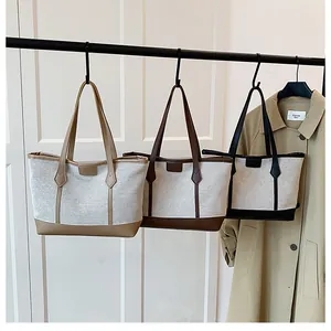 Close-up of minimalist canvas tote bags with leather handles in khaki, brown and black