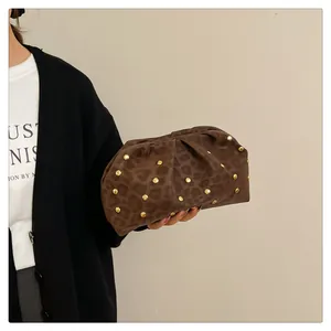 Close-up of leopard print clutch with gold studs and pleated faux leather design