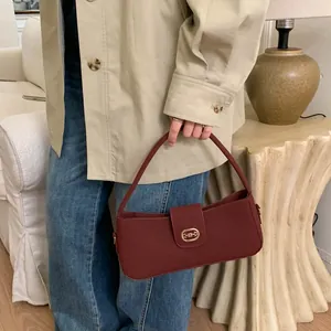 Detail view of burgundy retro leather handbag with vintage gold horsebit buckle