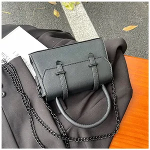 Detail of black mini square bag with cross-grain leather texture and metal chain strap
