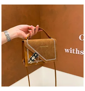 Detail of brown crossbody bag with herringbone stitching and fashion bags lettering