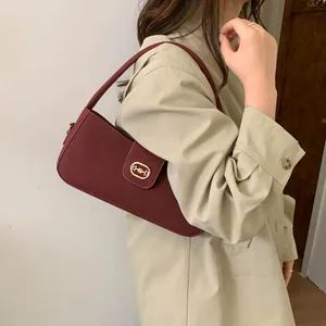 Chic burgundy shoulder bag in high-quality faux leather shown on a beige trench coat