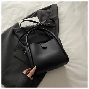 Close-up of black bucket bag with smooth matte texture and elegant top handle