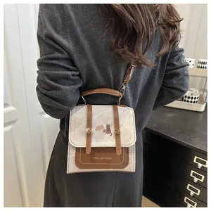 Detail showing vintage mini square bag with contrast trim and cat motif on model