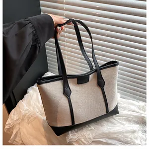 Detailed view of canvas tote bag with contrast leather trim and sturdy dual handles