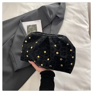 Detail of black leopard print clutch bag with golden rivets and elegant pleated design