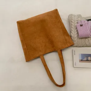 Flat lay of brown corduroy tote bag showing soft ribbed texture and wide handles