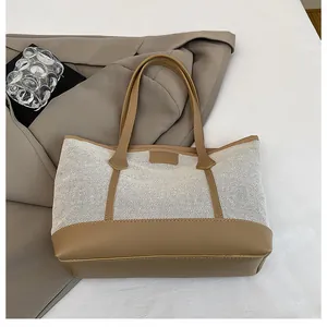 Detail of contrast stitching on mesh and leather tote bag with sturdy handles