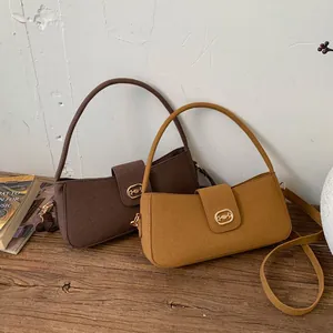 Detail of trendy crossbody bags in brown and mustard yellow with gold buckles