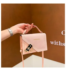 Detail of pink faux suede handbag with golden metal lock and elegant chain strap