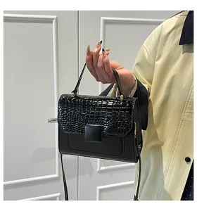 Detail view of black crocodile pattern faux leather on a minimalist luxury handbag