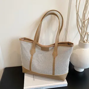 Minimalist mesh tote bag with tan leather trim and long shoulder straps on white background