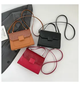 Detailed flat lay of crocodile texture handbags in brown, black, and red colors