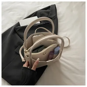 Detail view of the beige bucket bag showing interior multi-layer storage and compartments
