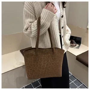 Close-up of leopard print tote bag showing soft suede texture and slim shoulder straps