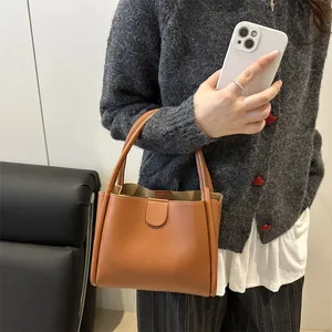 Minimalist brown leather bucket bag with top handle and magnetic closure for daily wear