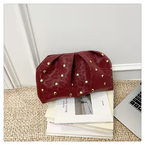 Detail view of burgundy leopard print handbag with golden studs and ruched leather texture
