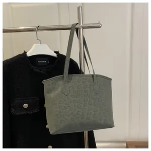 Close-up of olive green leopard print tote bag with matte texture on a hanger